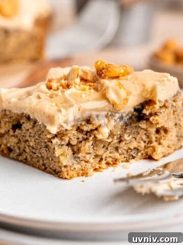 A slice of banana snack cake on a plate with a fork.