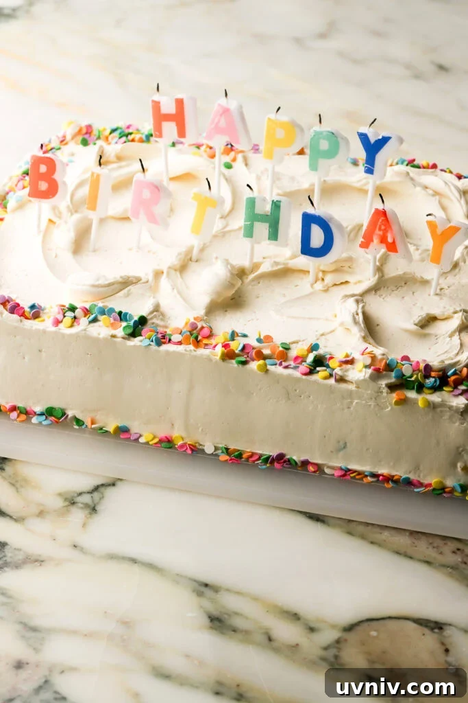 Party-Size Vanilla Birthday Sheet Cake Recipe 18 cake fully frosted and decorated with 'happy birthday' rainbow candles and confetti sprinkles