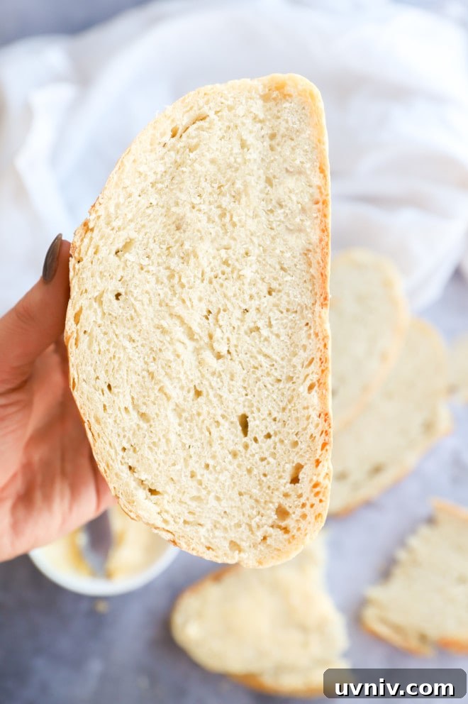 No-Knead Overnight Bread Recipe for Perfect Rustic Loaves 10 Hand holding a loaf sliced in half