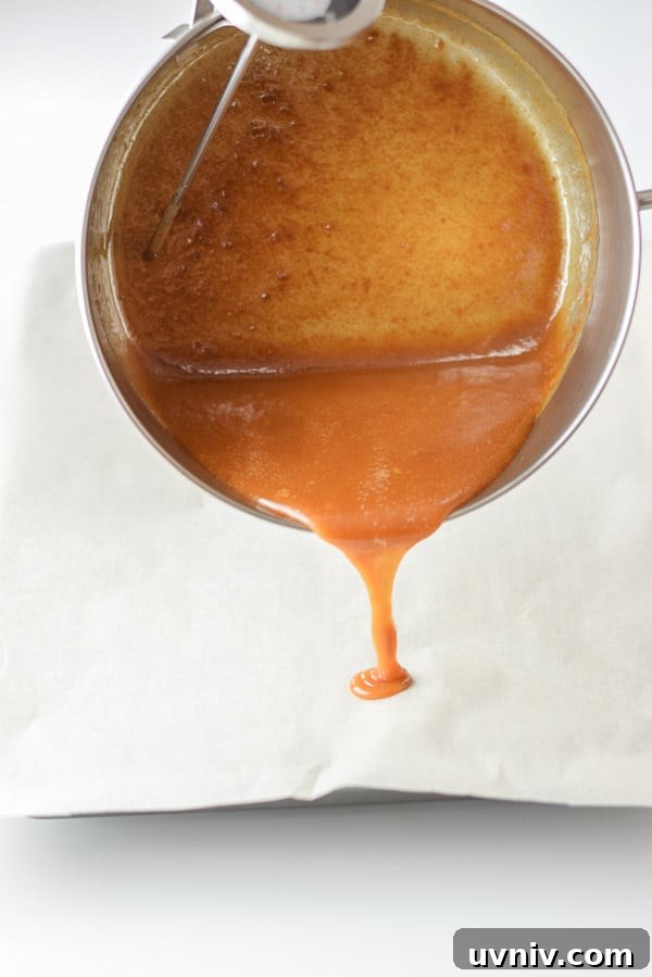 How to Make Soft, Chewy Caramels at Home 6 A pan dribbling caramel sauce on parchment paper