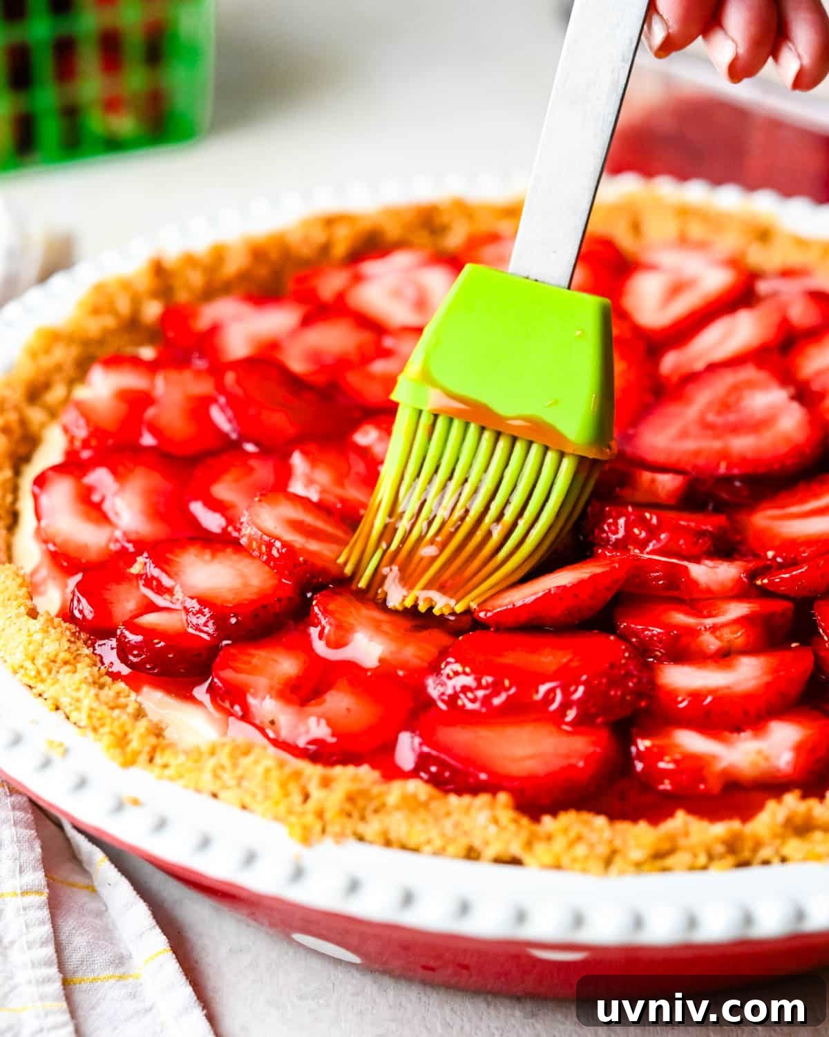 brushing the strawberry pie with glaze.