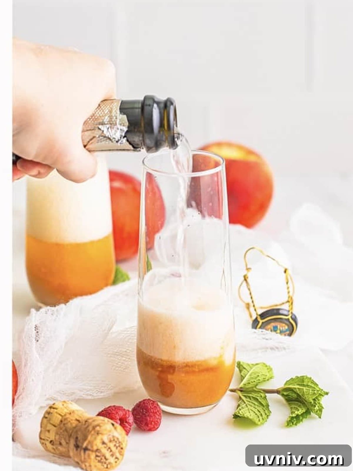 Prosecco poured into a glass with peach puree to make a peach bellini.