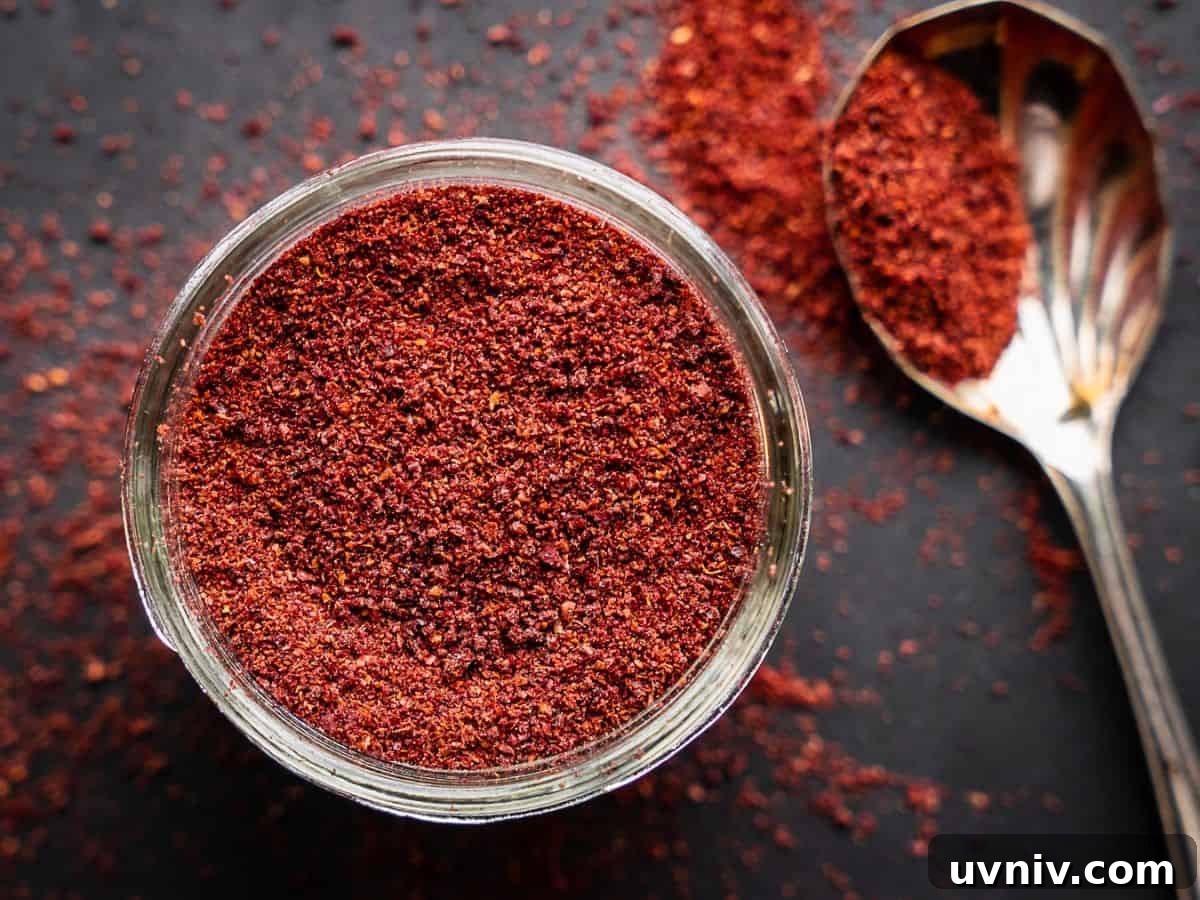 Sumac: Uses, Recipes, and the Spice’s Story 2 Sumac spice with spoon in an open mason jar.
