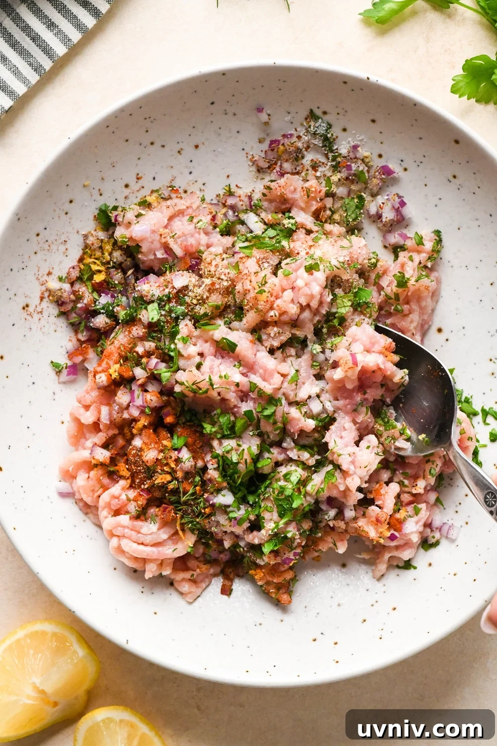 How to make Greek chicken meatballs: Ingredients for meatballs in a large bowl, during mixing.