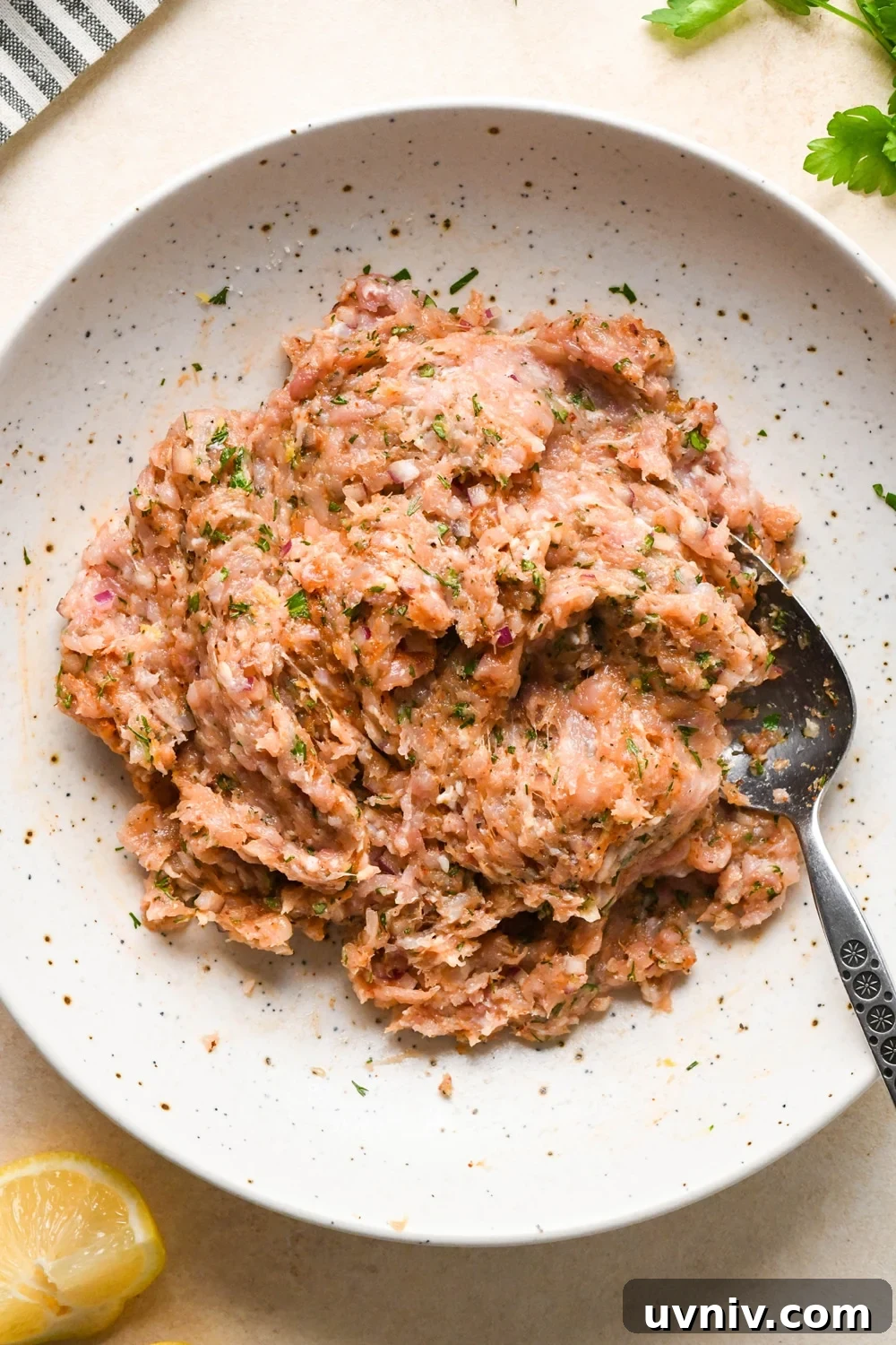 How to make Greek chicken meatballs: Ingredients for meatballs in a large bowl, after mixing together.