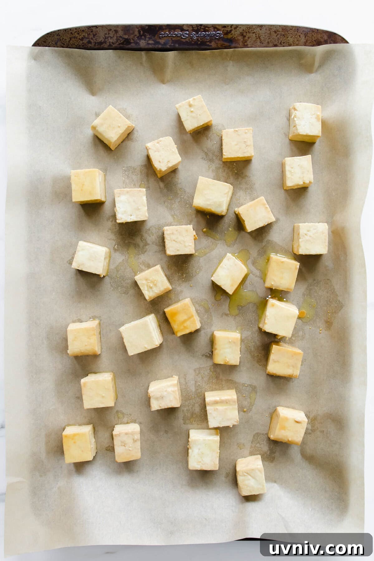 Crispy Baked Peanut Butter Tofu with Sticky Soy Glaze 4 cubes of tofu on a baking sheet.