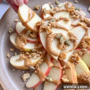 Healthy apple nachos on a plate with peanut butter and granola