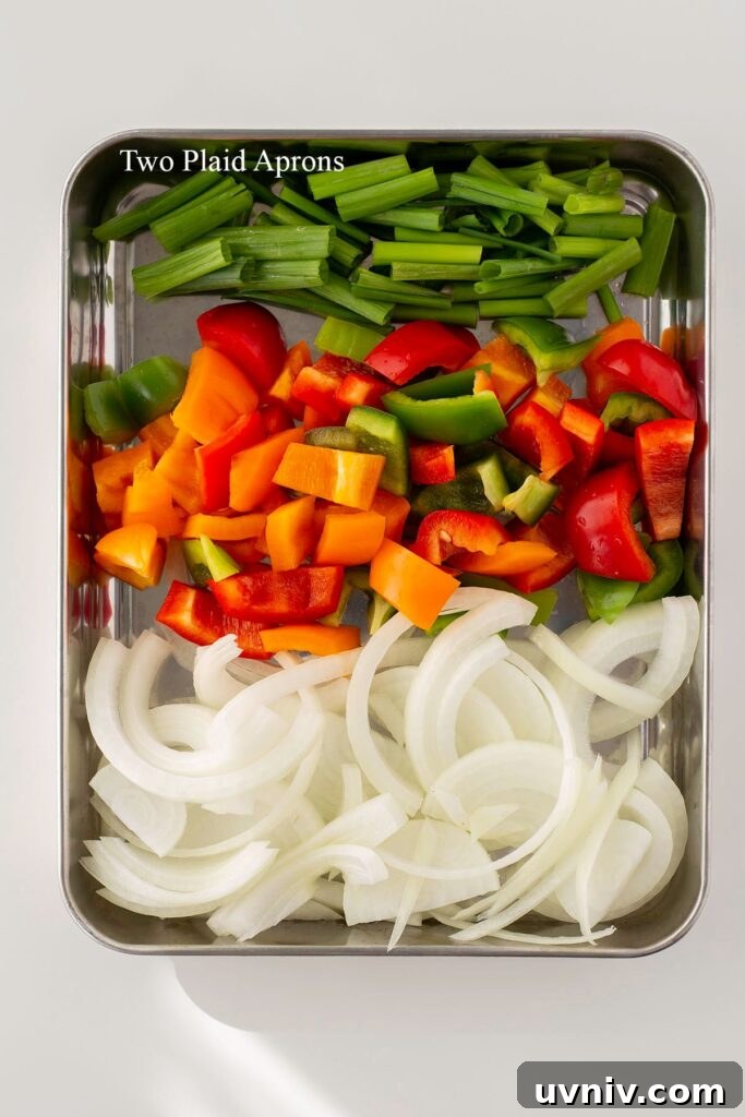 Spicy Korean Sausage Stir-Fry with Vegetables 6 Thinly sliced yellow onion, diced tri-color bell peppers, and green onion prepared for the sausage bokkeum.