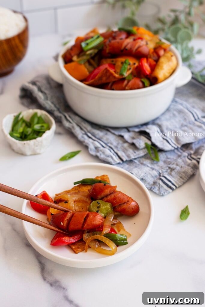 Spicy Korean Sausage Stir-Fry with Vegetables 9 Picking up a piece of sausage from the Korean sausage stir fry.