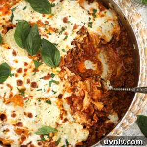Overhead view of skillet lasagna with portion removed