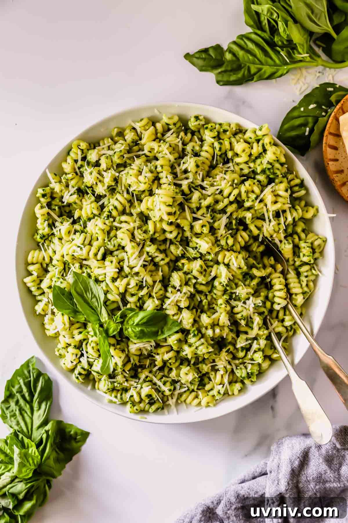 Creamy Basil Pesto Pasta Recipe for Quick Weeknight Meals 7 A bowl of basil pesto pasta with two forks sticking out.