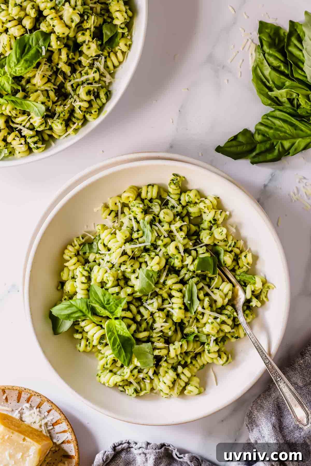 Creamy Basil Pesto Pasta Recipe for Quick Weeknight Meals 8 A bowl of basil pesto pasta with a fork and a second bowl of pasta to the side.