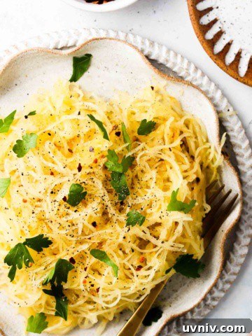 Easy air fryer spaghetti squash on a plate with fresh green herbs.
