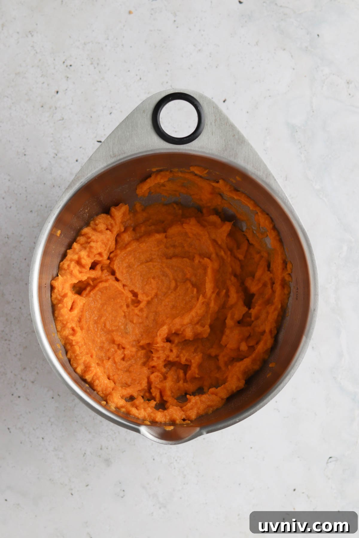 Vegan sweet potato mash in a metal mixing bowl.