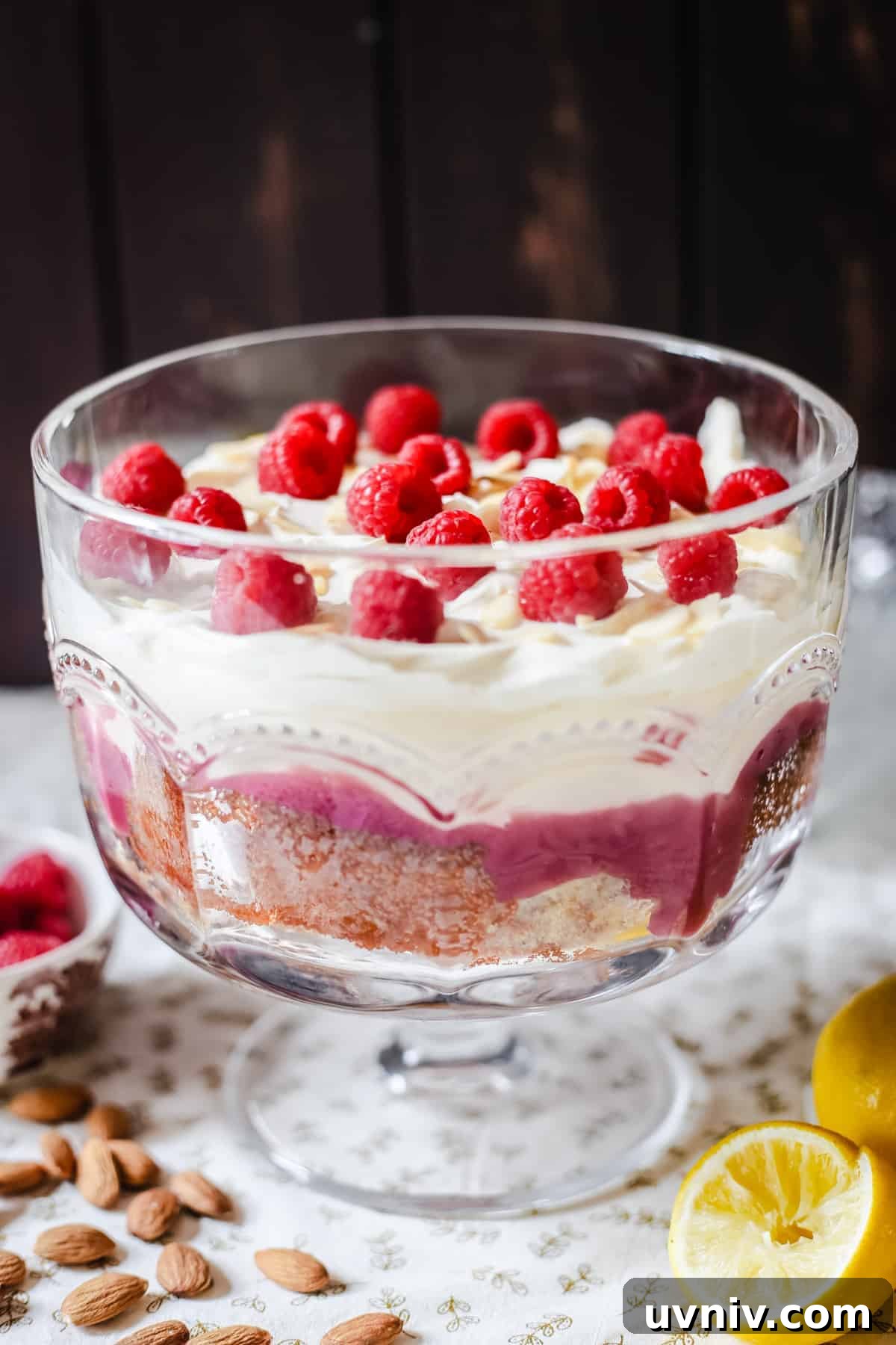 Gluten-Free Lemon and Raspberry Trifle Recipe for Spring Desserts 2 A large glass bowl of trifle on a table topped with raspberries