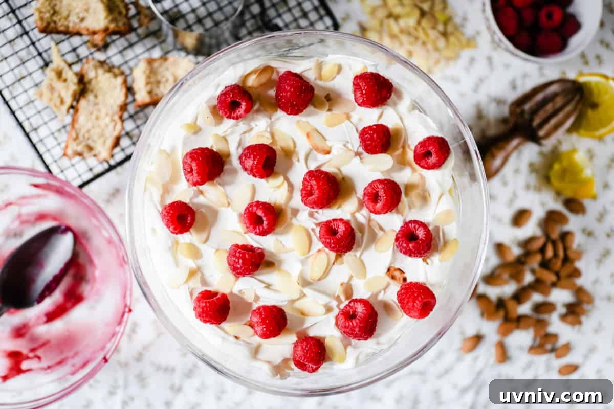 Gluten-Free Lemon and Raspberry Trifle Recipe for Spring Desserts 7 A large glass bowl of trifle from above on a table topped with raspberries and almonds