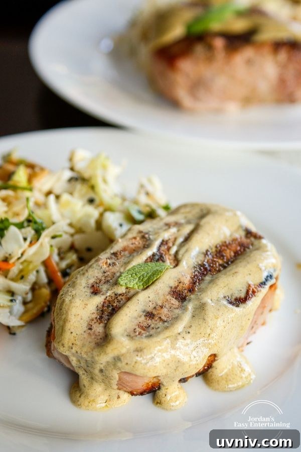 two plates of juicy grilled pork chops topped with sage mustard cream sauce