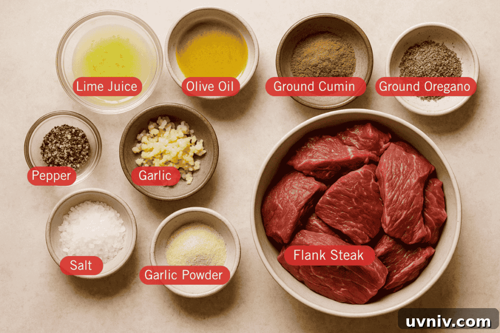 Authentic Carne Asada Recipe for Juicy Grilled Steak 2 A flatlay photo of labeled carne asada ingredients on a light beige surface. At the center right is a bowl of raw flank steak slices. Surrounding it are small bowls containing lime juice, olive oil, ground cumin, ground oregano, minced garlic, garlic powder, salt, and cracked black pepper.