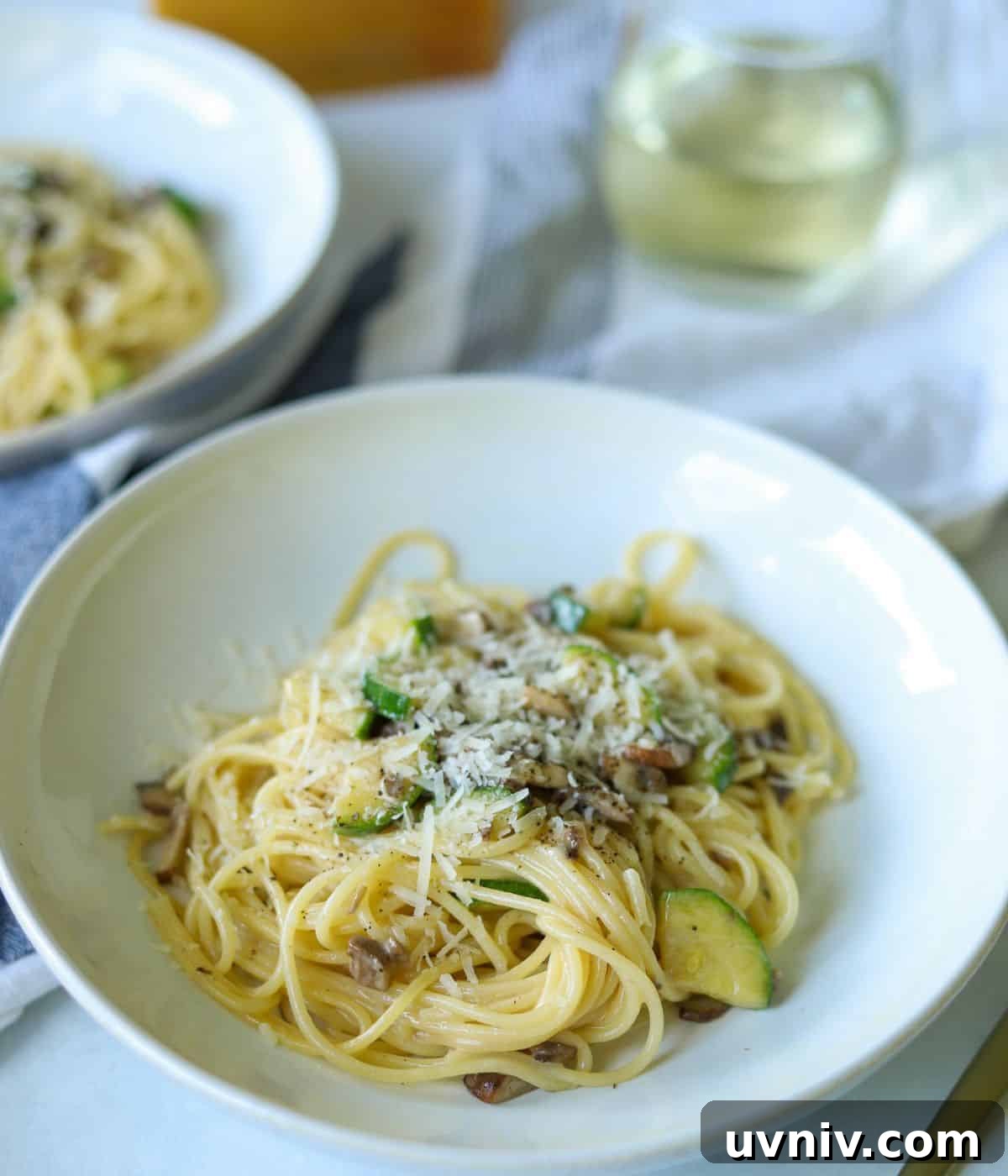 bowl of mushroom zucchini pasta topped with cheese