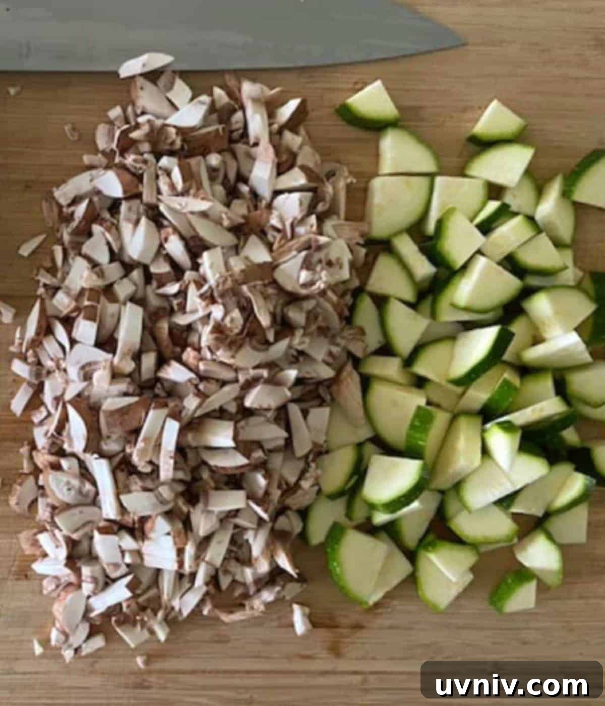 Zucchini and mushrooms diced on cutting board.