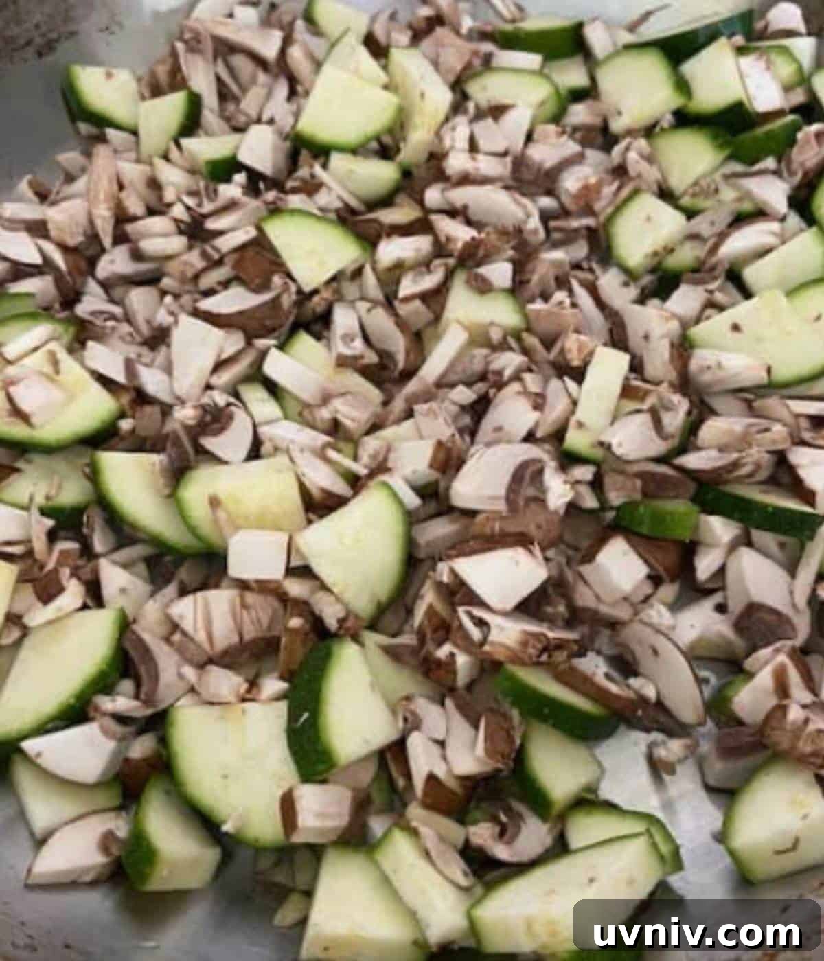 Mushroom and zucchini cooking in pan.