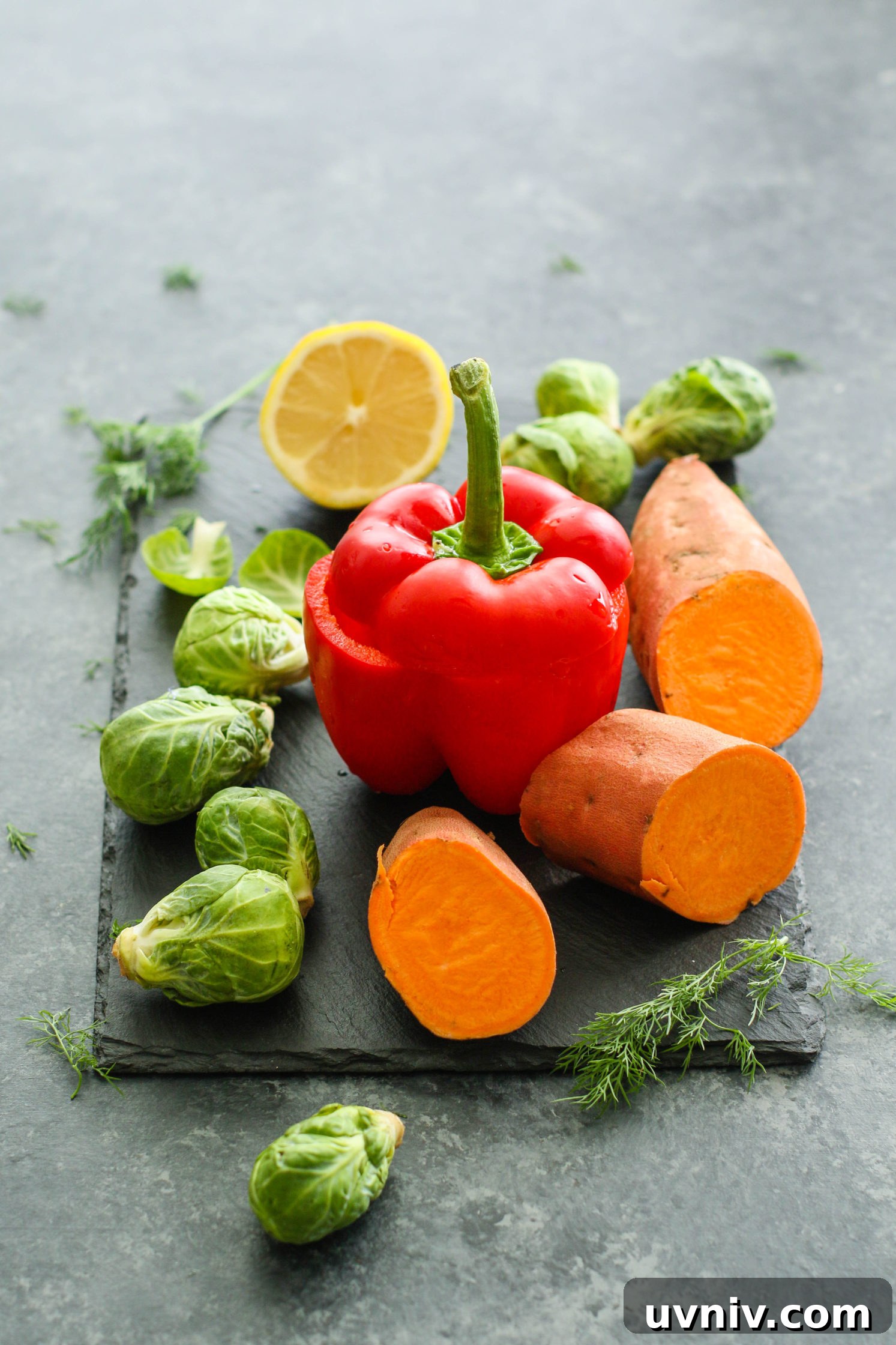 bell pepper, sweet potato, brussels sprouts, and lemon on a cutting board by Flora & Vino