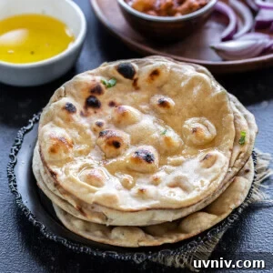 How to Make Authentic Tandoori Roti at Home 8 stack on rotis with bowl of ghee and bowl of curry in the background