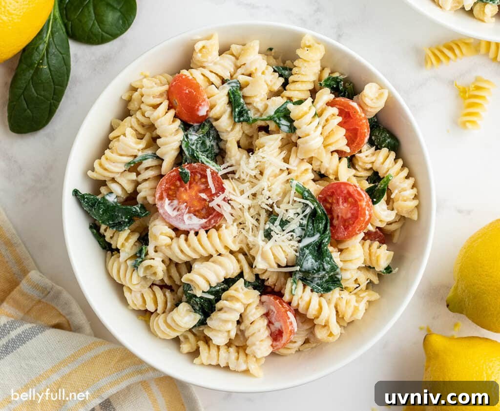 Creamy Lemon Pasta Recipe with Garlic and Parmesan 5 overhead picture of rotini pasta with tomatoes and spinach in white bowl