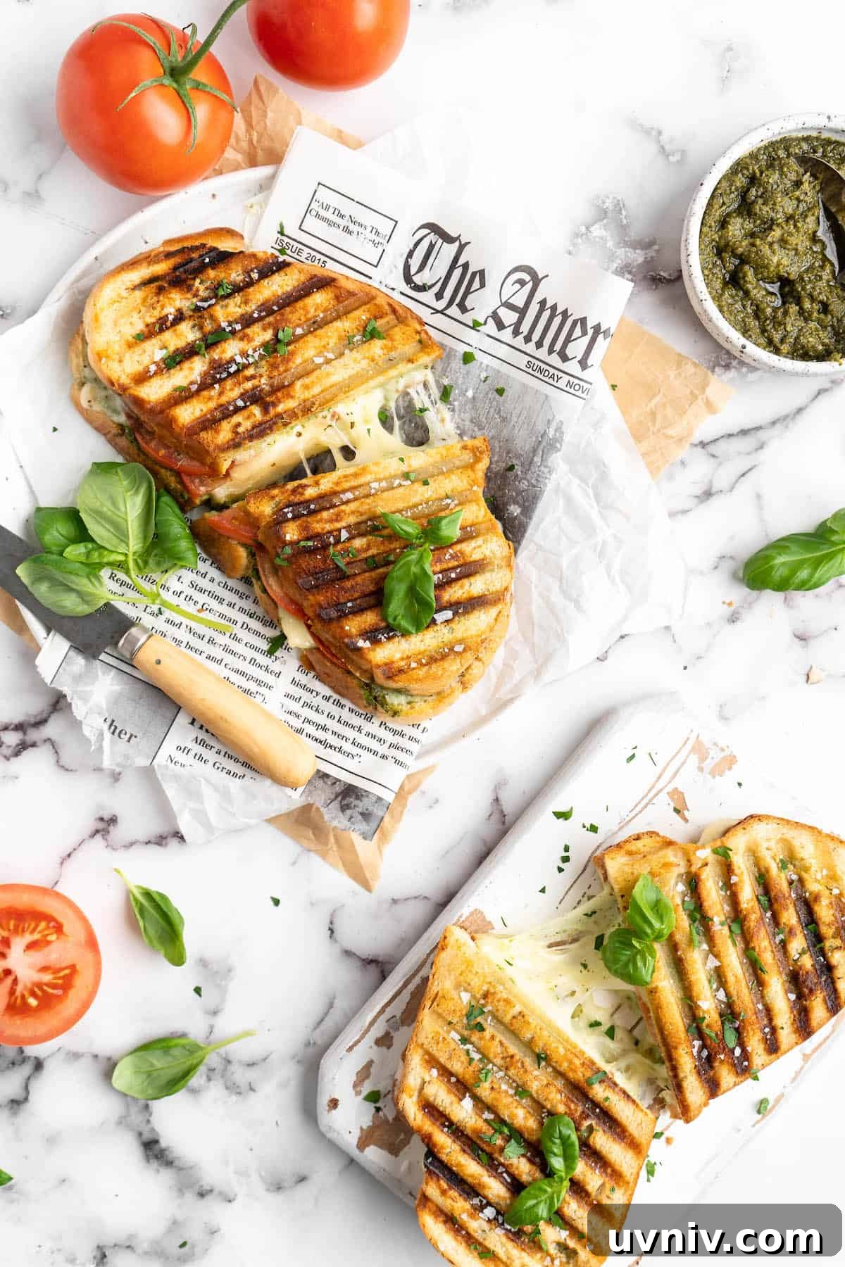This vegan Caprese sandwich layers plant-based mozzarella with fresh tomatoes and parsley pesto, all on crusty French bread. Best lunch ever! Vegan caprese sandwiches, cut in half to show stretchy mozzarella
