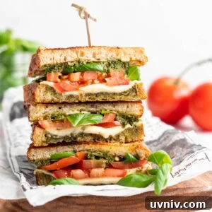 Caprese Sandwich with Bright Parsley Pesto Recipe 2 Three stacked vegan caprese sandwiches set on wooden cutting board