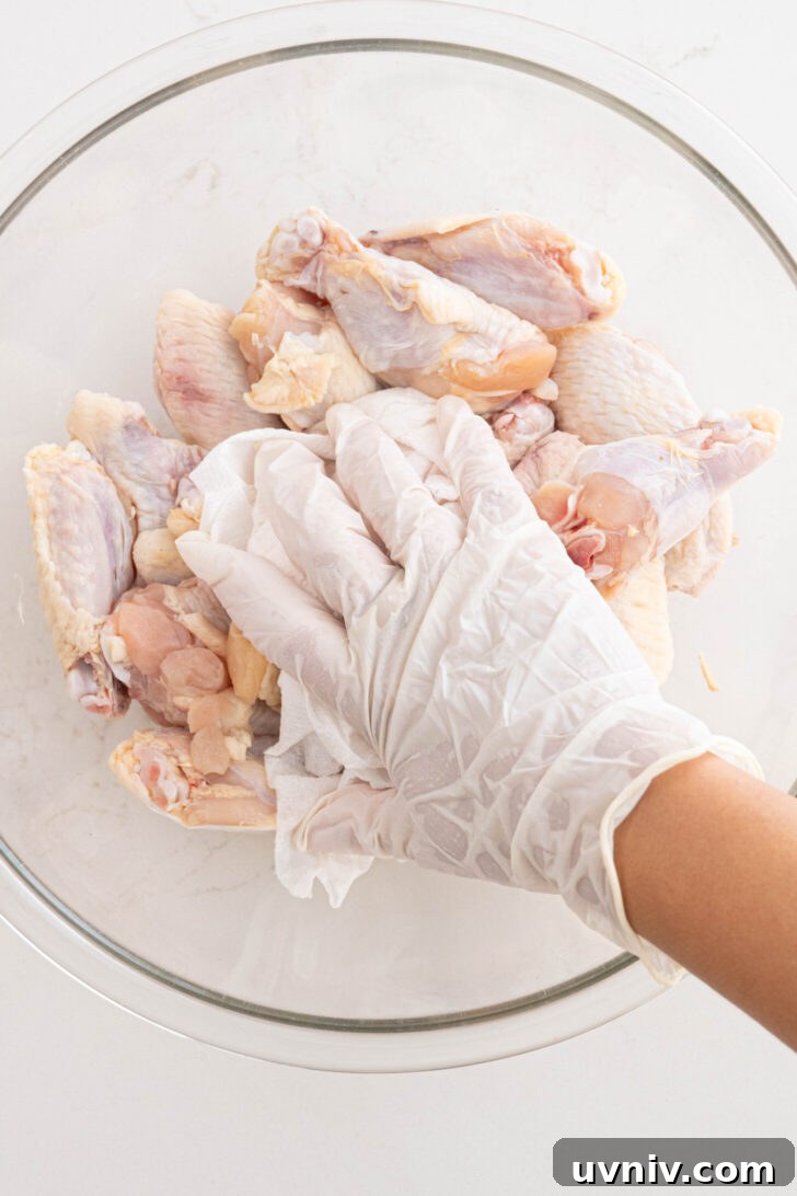 Mango Habanero Chicken Wings with Sticky Glaze 5 Wings being patted dry with paper towel.