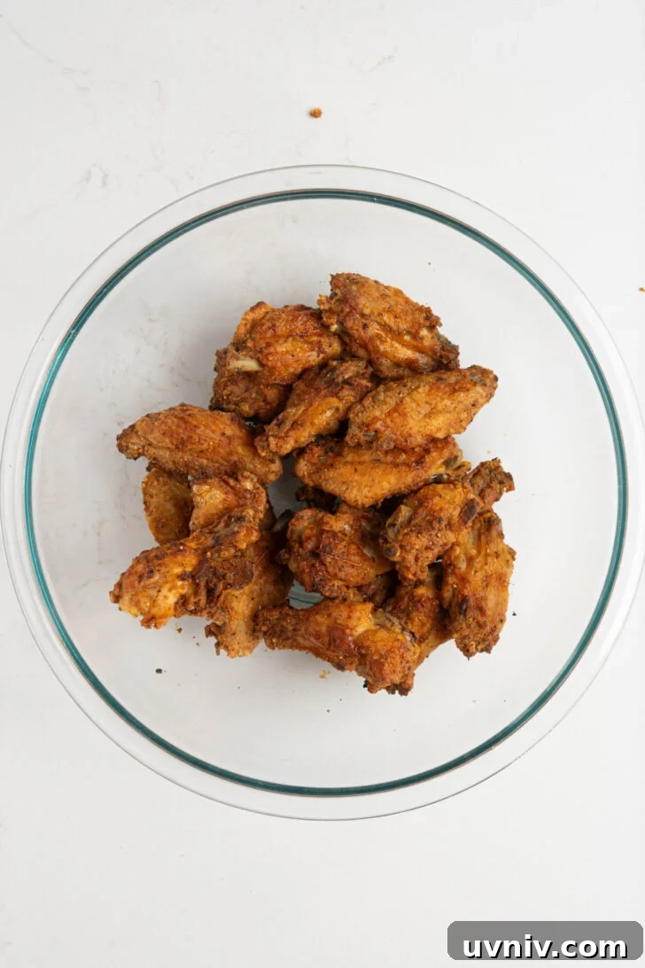 Mango Habanero Chicken Wings with Sticky Glaze 7 Crispy baked wings in a bowl.