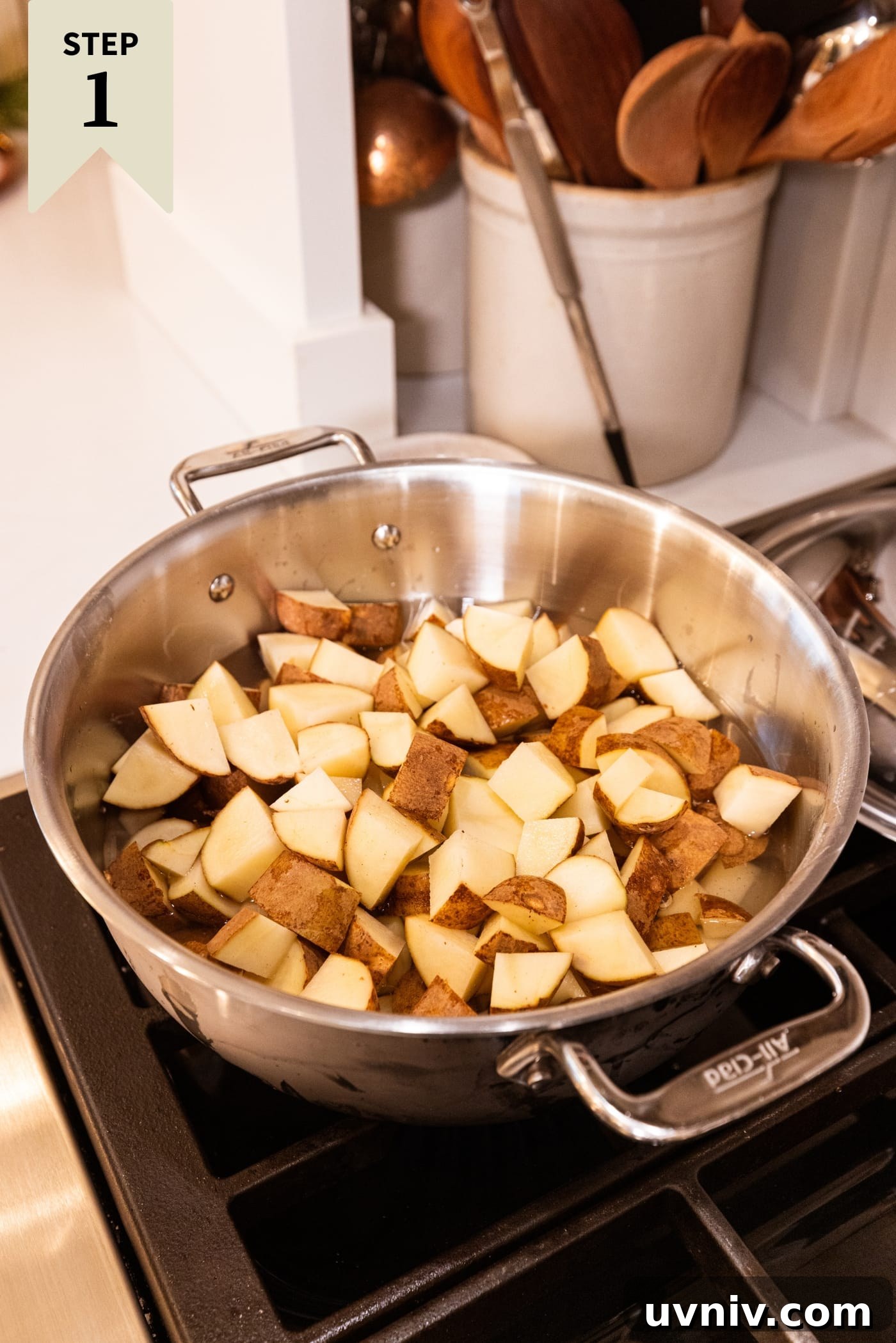 French Onion Potato Casserole Recipe with Melty Cheese 5 Large stockpot sitting on the stove with cubed pieces of raw potato.