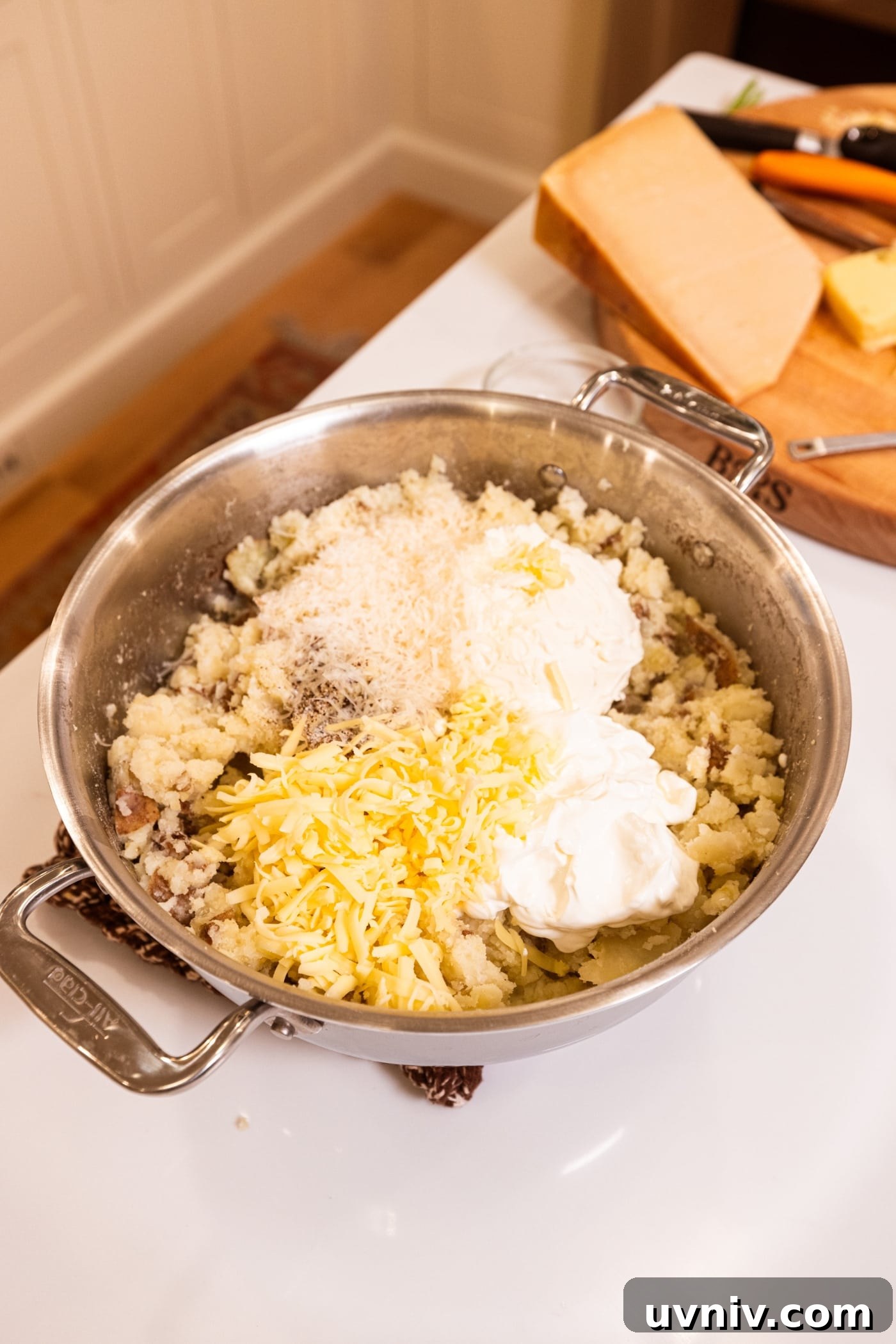 French Onion Potato Casserole Recipe with Melty Cheese 10 Mashed potatoes in large stockpot with cheese, sour cream, and cream cheese on top.