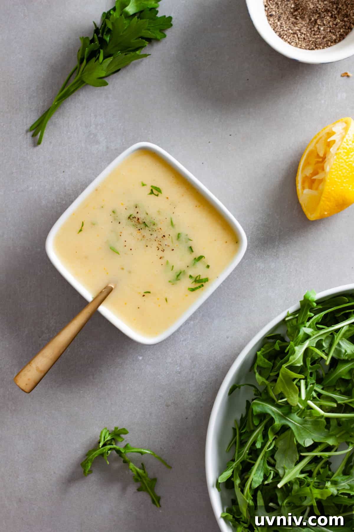 Zesty Preserved Lemon Vinaigrette Recipe for Salads & Marinades 2 A small white bowl of preserved lemon vinaigrette topped with chopped parsley.
