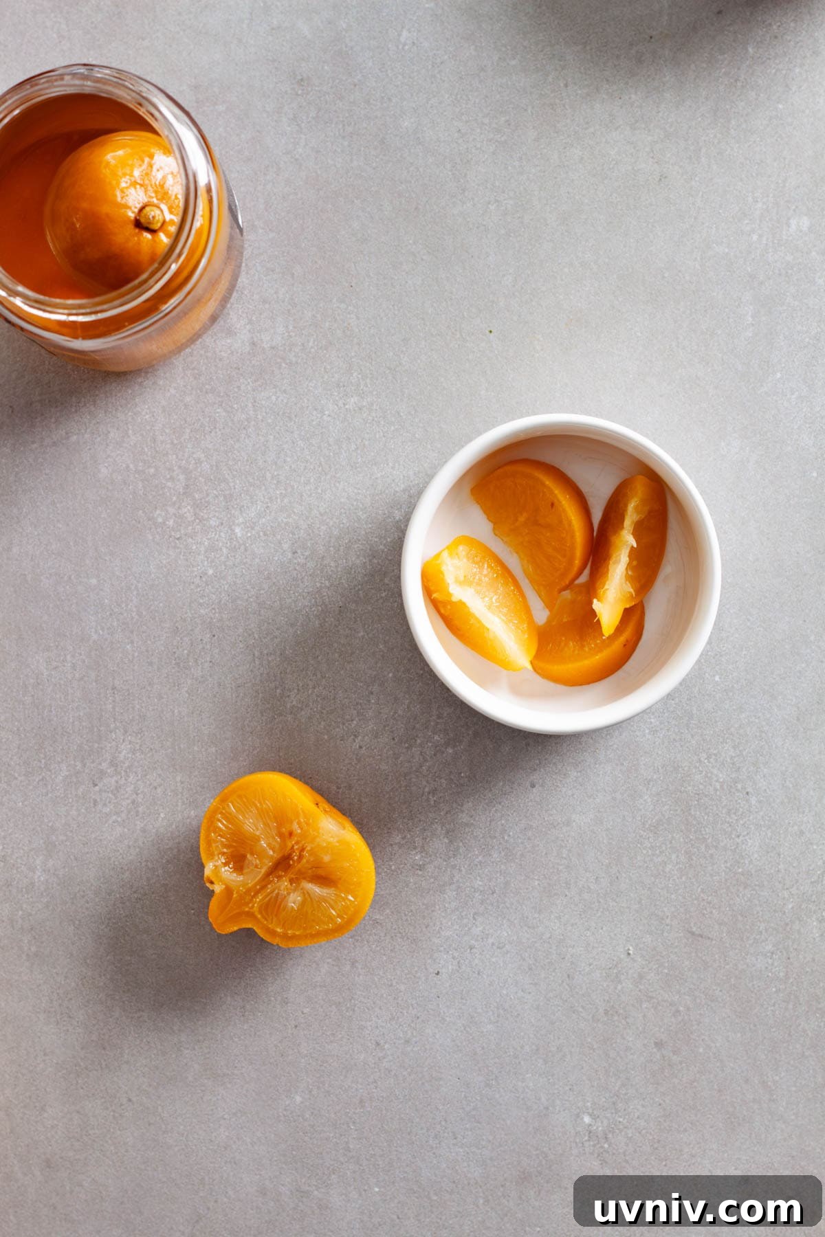 Zesty Preserved Lemon Vinaigrette Recipe for Salads & Marinades 9 Sliced preserved lemons in a small white bowl with a glass jar of whole preserved lemons to the side.
