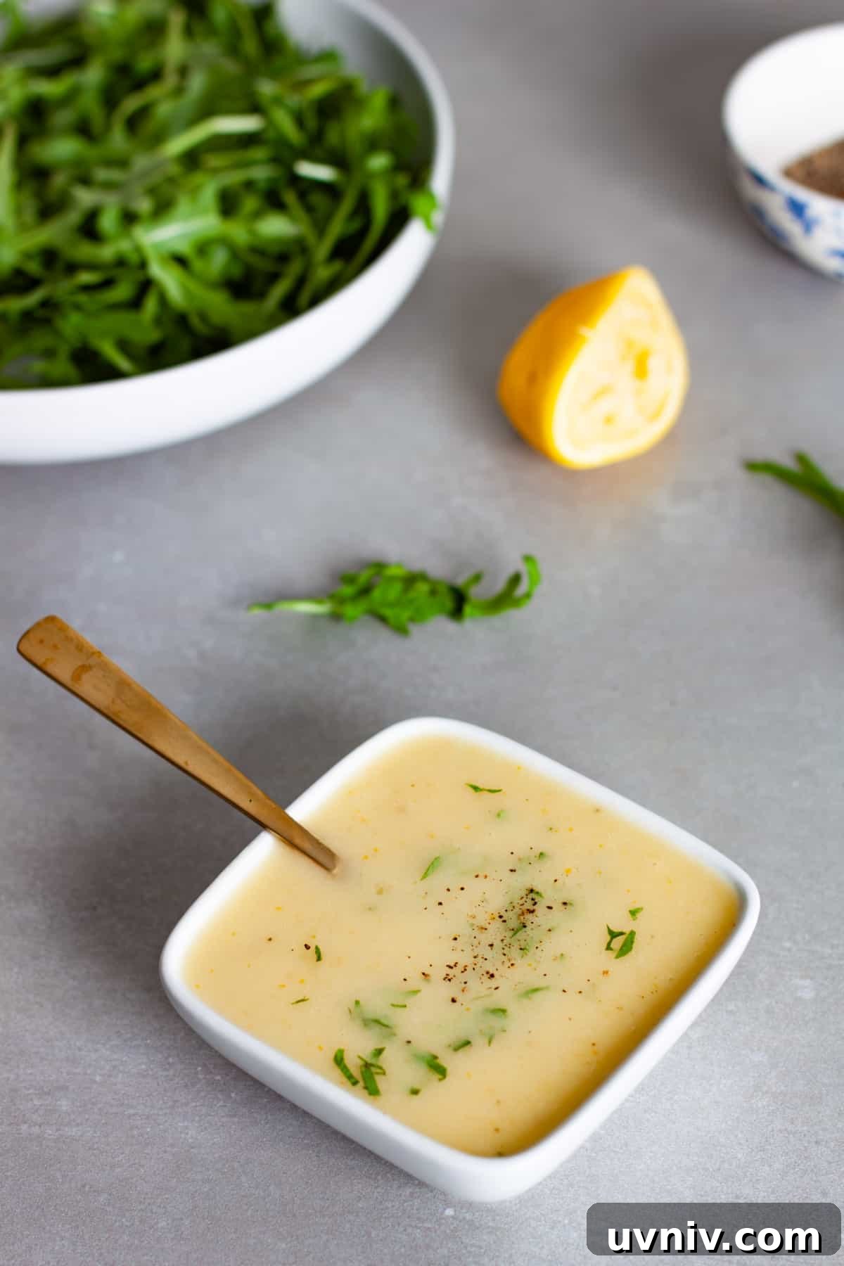 Zesty Preserved Lemon Vinaigrette Recipe for Salads & Marinades 10 A small white bowl of preserved lemon vinaigrette topped with chopped parsley.