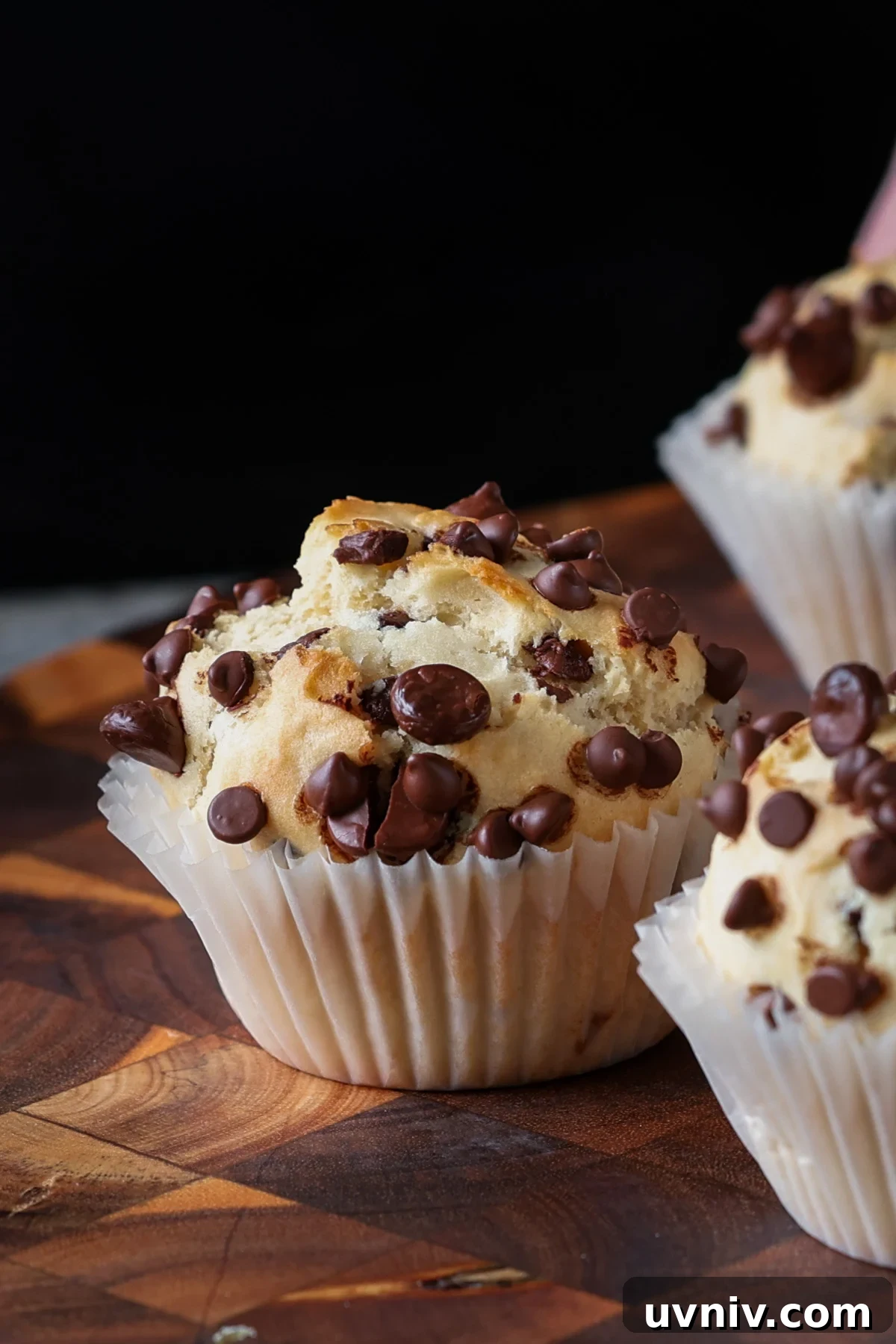 chocolate chip muffin on a wooden cutting board