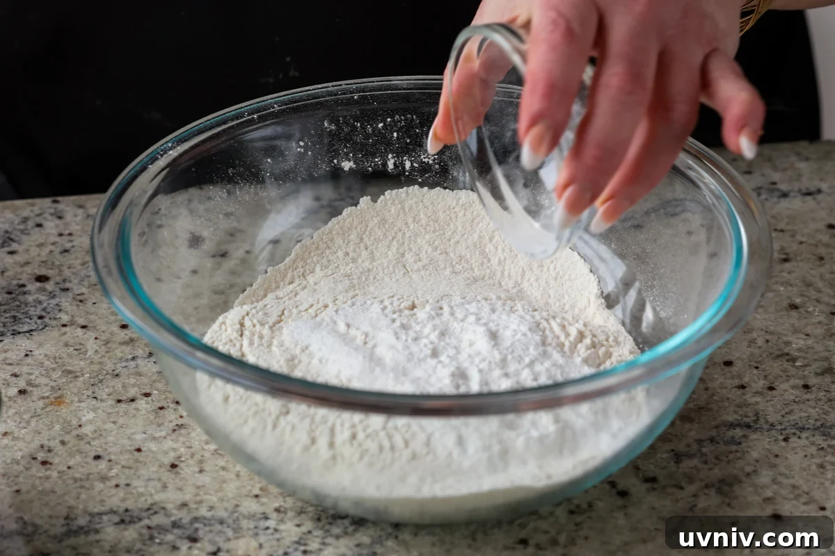 adding dry ingredients to a bowl
