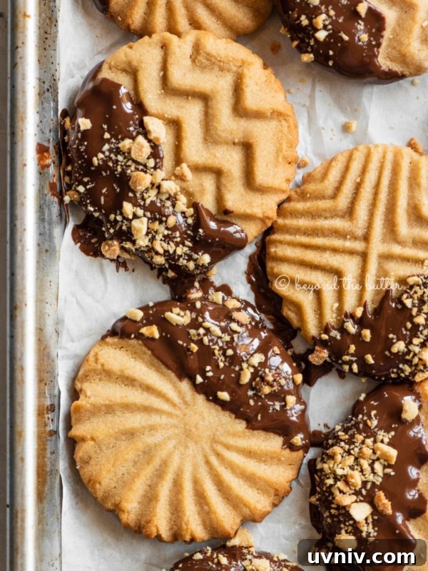 Baking sheet with randomly placed chocolate dipped peanut butter cookies.