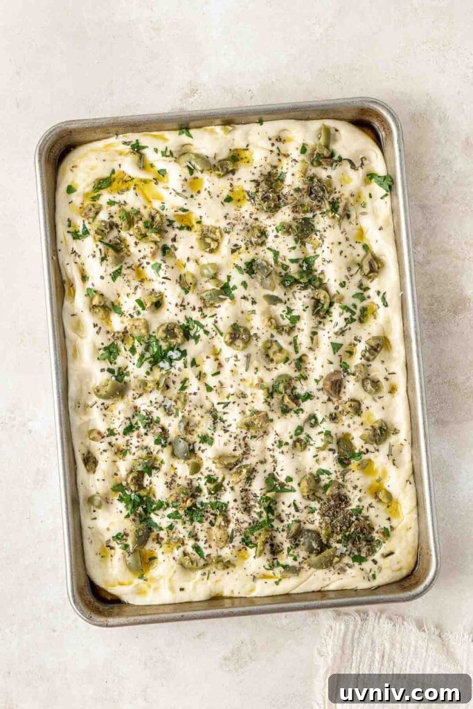 Olive & Herb Focaccia Recipe — Crispy, Flavorful Italian Bread 10 Toppings added to the focaccia dough, ready for the oven.