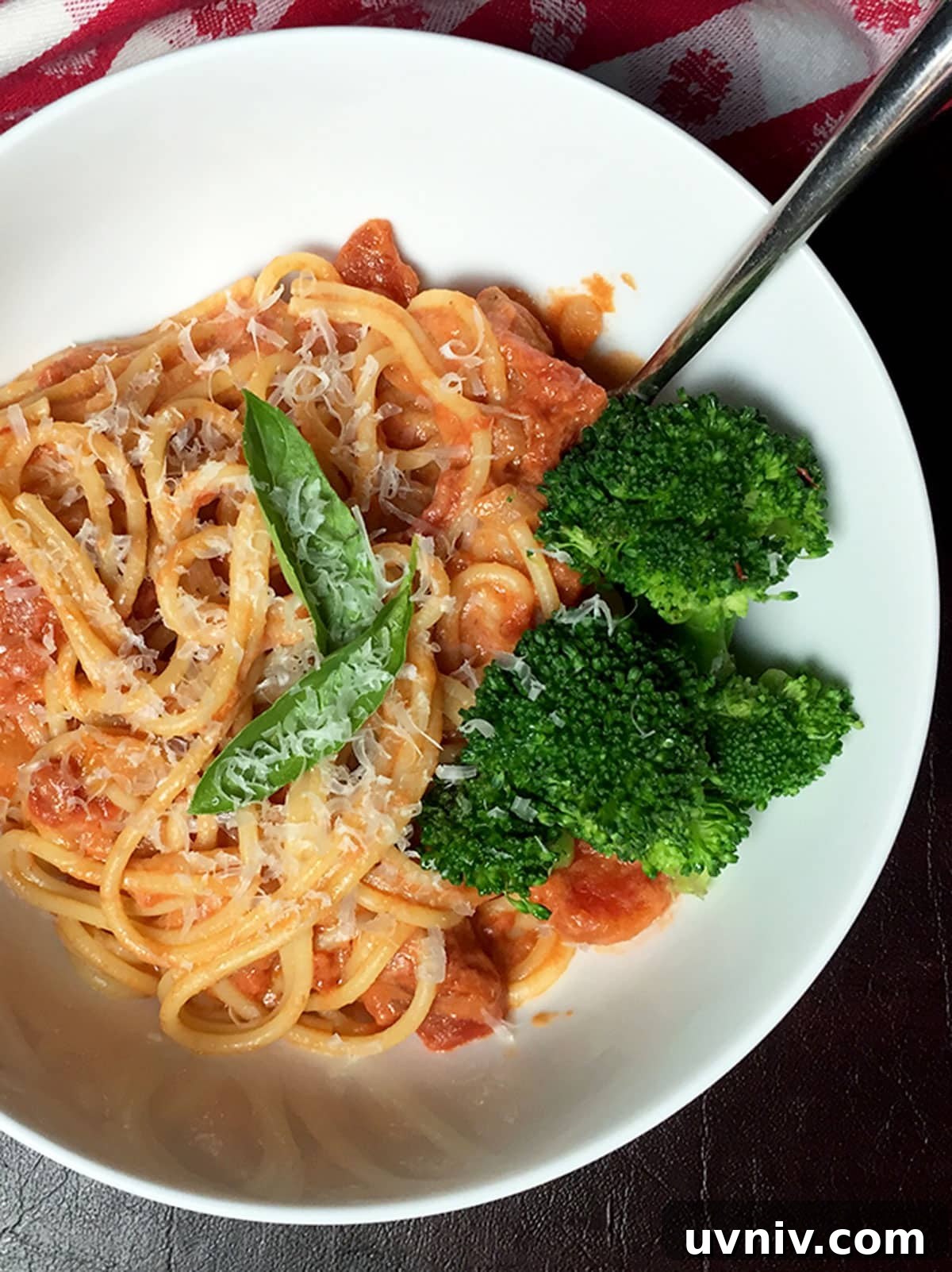 Roasted Tomato Sauce Recipe — Rich Flavor in Minutes 11 White bowl of pasta with roasted tomato sauce on it and basil and broccoli.