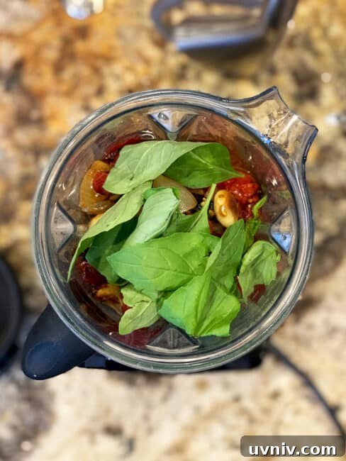 Roasted Tomato Sauce Recipe — Rich Flavor in Minutes 7 Fresh basil on top of the roasted tomato ingredients in the blender.