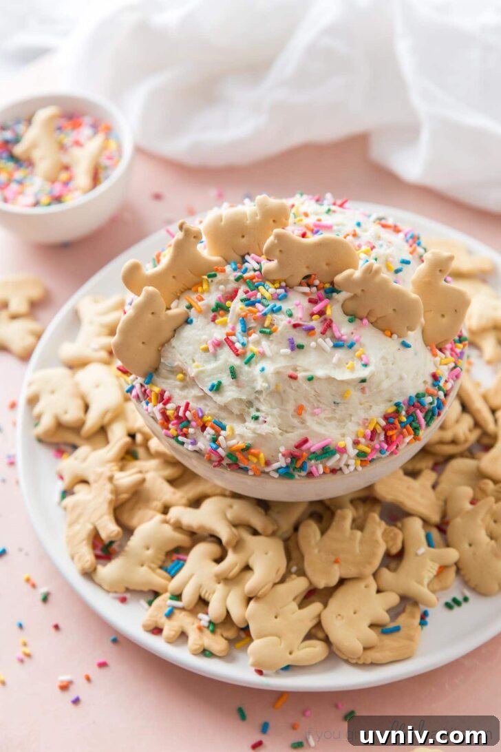Funfetti Cake Dip Recipe — Party-Friendly Dessert Dip 2 funfetti dip in light pink bowl with animal crackers
