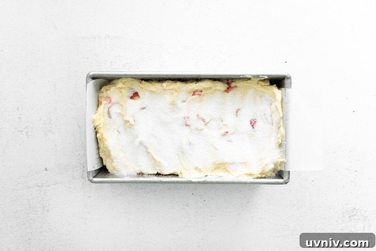 Strawberry Rhubarb Layer Cake Recipe for Summer Baking 9 cake batter topped with sugar in a loaf pan.