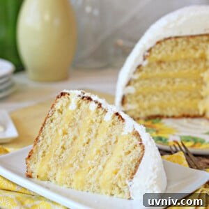 Zesty Lemon Bars: Classic Tangy Dessert Bar Recipe 19 A slice of Lemon Coconut Snowball Cake on a small square plate with the rest of the cake in the background.