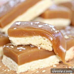 Zesty Lemon Bars: Classic Tangy Dessert Bar Recipe 9 Close up of 2 stacked salted caramel bars with the caramel pulled on the top bar.