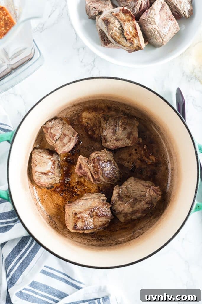 Chipotle Beef Barbacoa Recipe: Smoky Slow-Cooked Mexican Beef 7 golden brown beef chunks in a pot