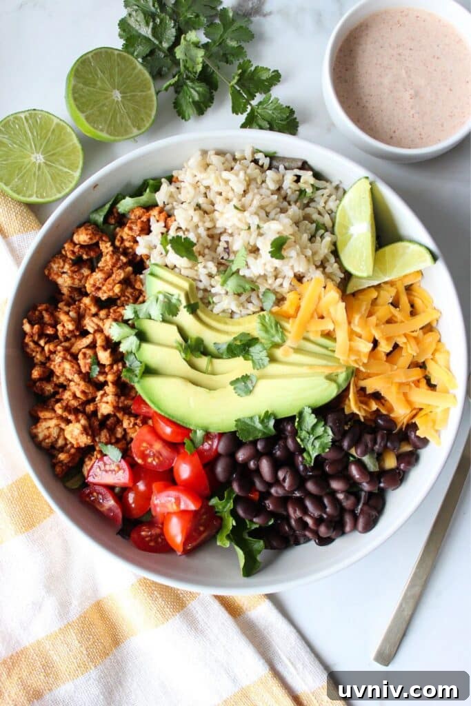Taco Rice Bowl with Seasoned Beef, Salsa & Avocado 4 A taco rice bowl with ground turkey, rice, avocado, tomato, black beans, and shredded cheese with a creamy taco dressing on the side.