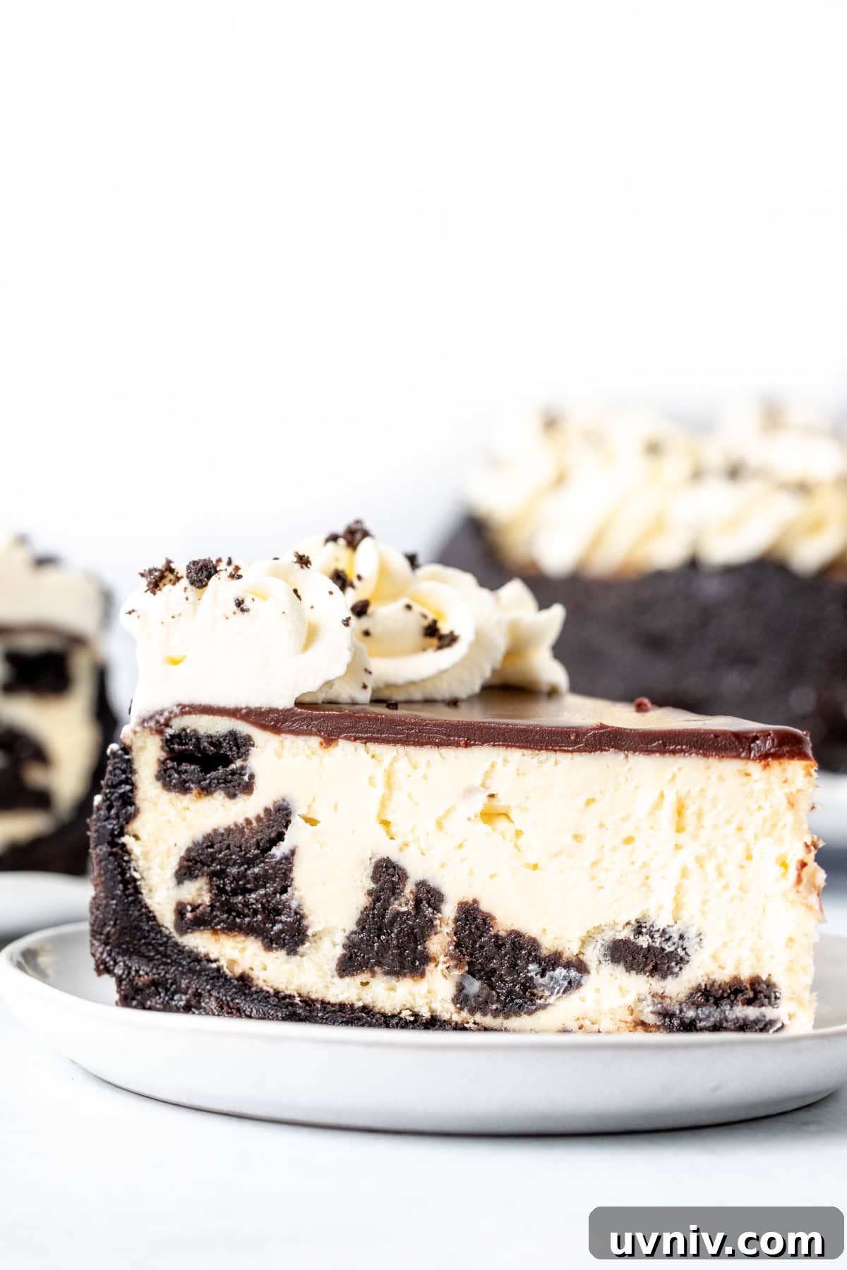 Decadent Oreo Cheesecake Recipe: Creamy Cookies & Cream Dessert 2 Slice of Oreo cheesecake with chocolate ganache topping and whipped cream